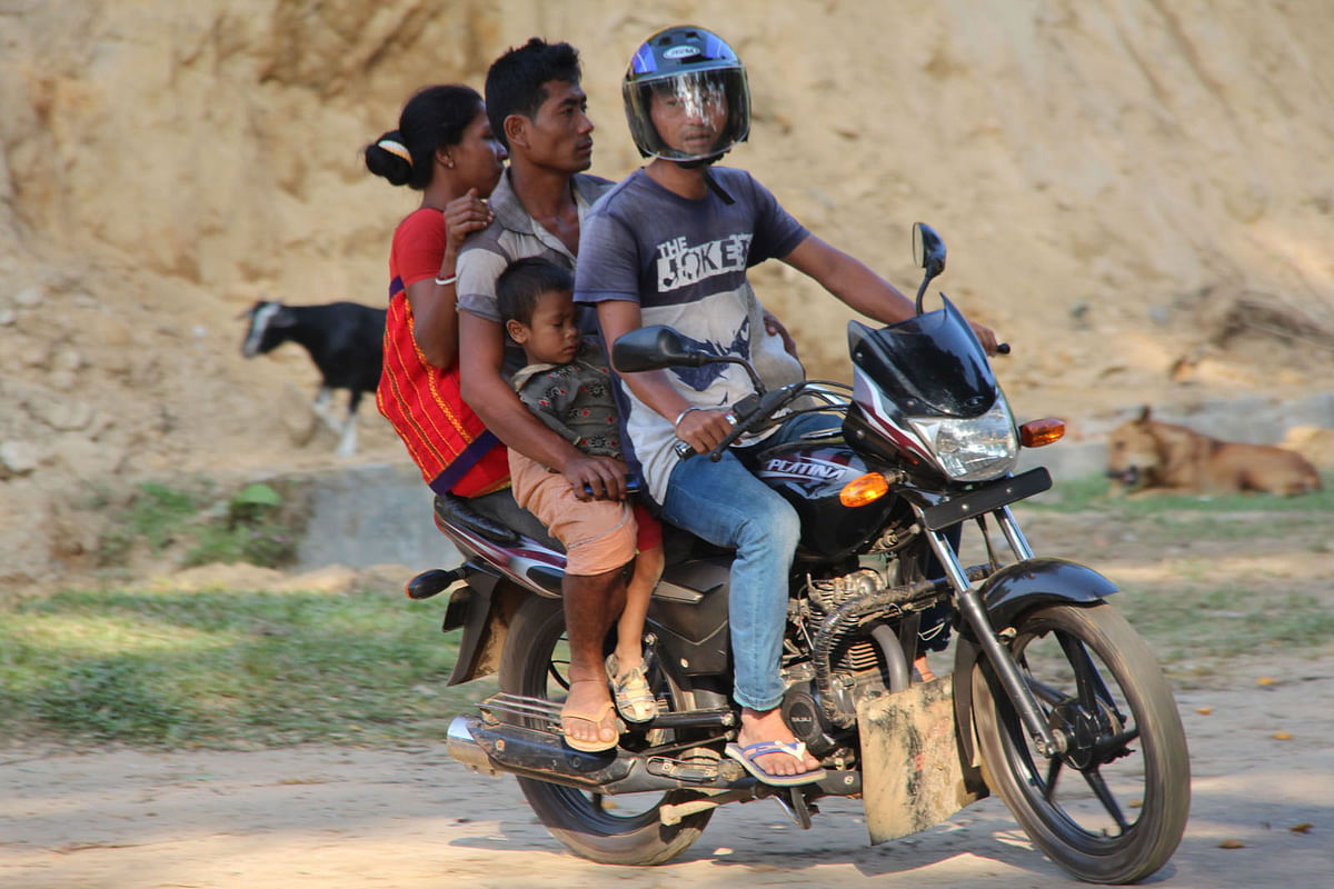 The motorcycle rider takes risk of carrying three people on the rough hilly roads in Bangmara area of Matiranga upazila of Khagrachhari on 27 October 2017. Photo: Nirob Chowdhury