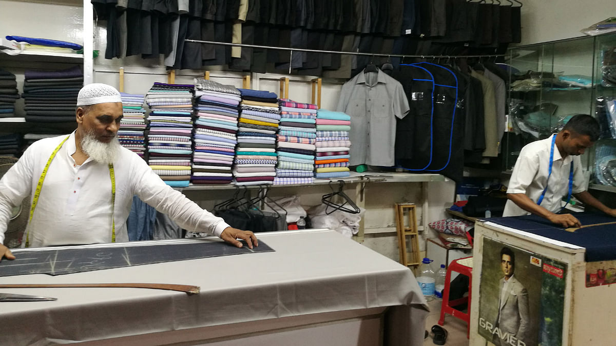 Tailor Abdul Mannan is taking measures of cloth at his shop. Photo: Saimul Huda