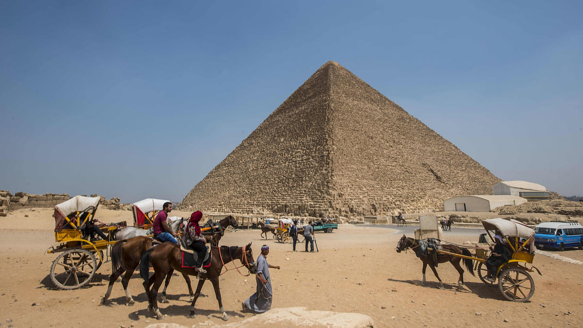 This file photo taken on 31 August, 2016 shows Egyptians riding their carts past the Great Pyramid of Cheops, aka Pyramid of Khufu, on the Giza Plateau, on the southern outskirts of the capital Cairo. Photo: AFP