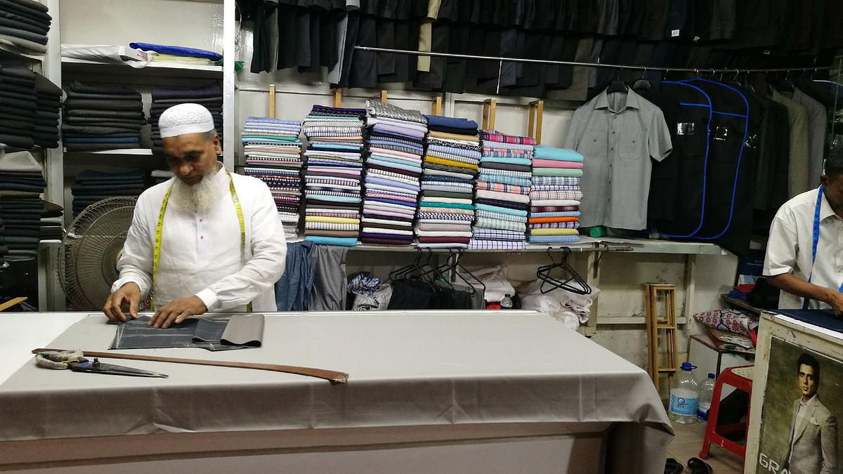 Tailor Abdul Mannan is cutting cloths at his shop. Photo: Saimul Huda