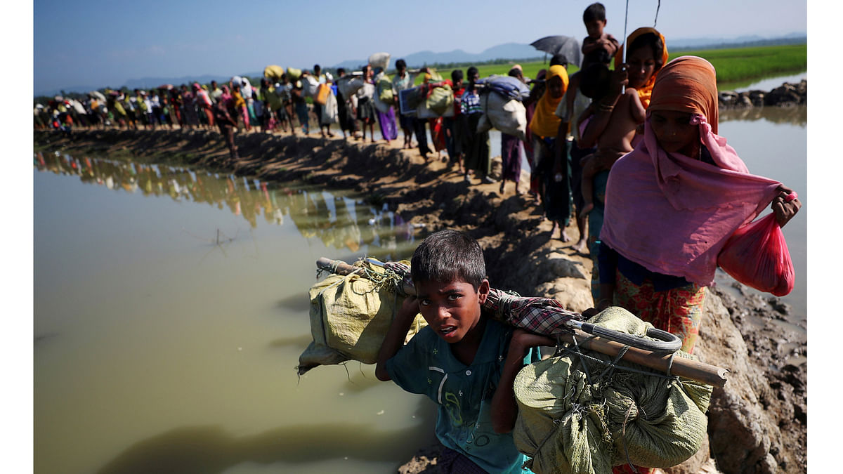 Rohingya refugees make their way to a refugee camp after crossing the Bangladesh-Myanmar border in Palong Khali, near Cox`s Bazar.File photo Reuters