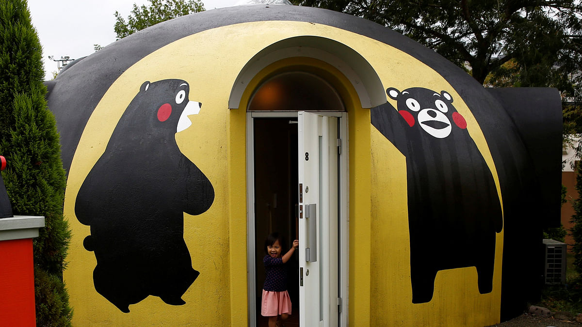 A girl from Singapore comes out of a quake-resistant dome house decorated with Japan`s popular `Kumamon` bear character at the Aso Farm Land resort in Aso. Reuters