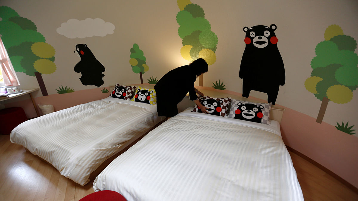 A staff arranges a bed at a quake-resistant dome house decorated with Japan`s popular `Kumamon` bear character at the Aso Farm Land resort, in Aso. Reuters