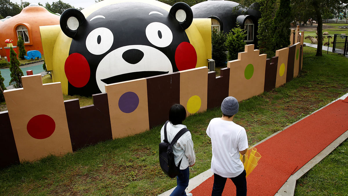 Visitors walk past a quake-resistant dome house decorated with Japan`s popular `Kumamon` bear character at the Aso Farm Land resort in Aso. Reuters