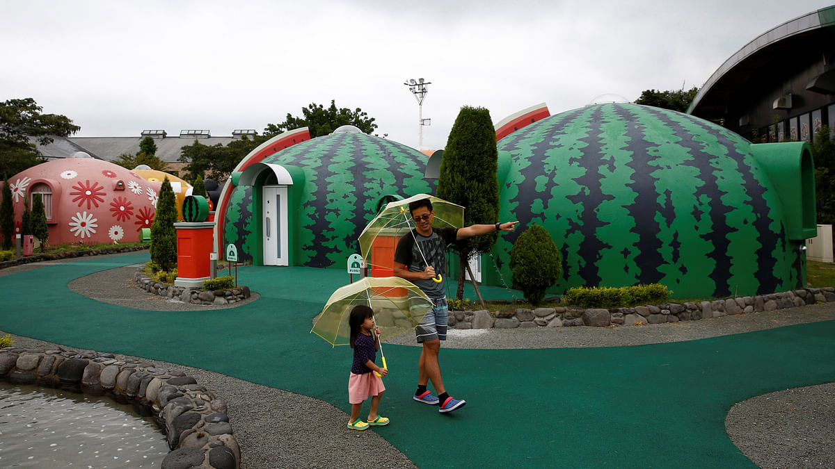 A family from Singapore takes a walk around quake-resistant dome houses at the Aso Farm Land resort in Aso, Kumamoto Prefecture, Japan September 15, 2017. Picture taken on September 15, 2017. Reuters
