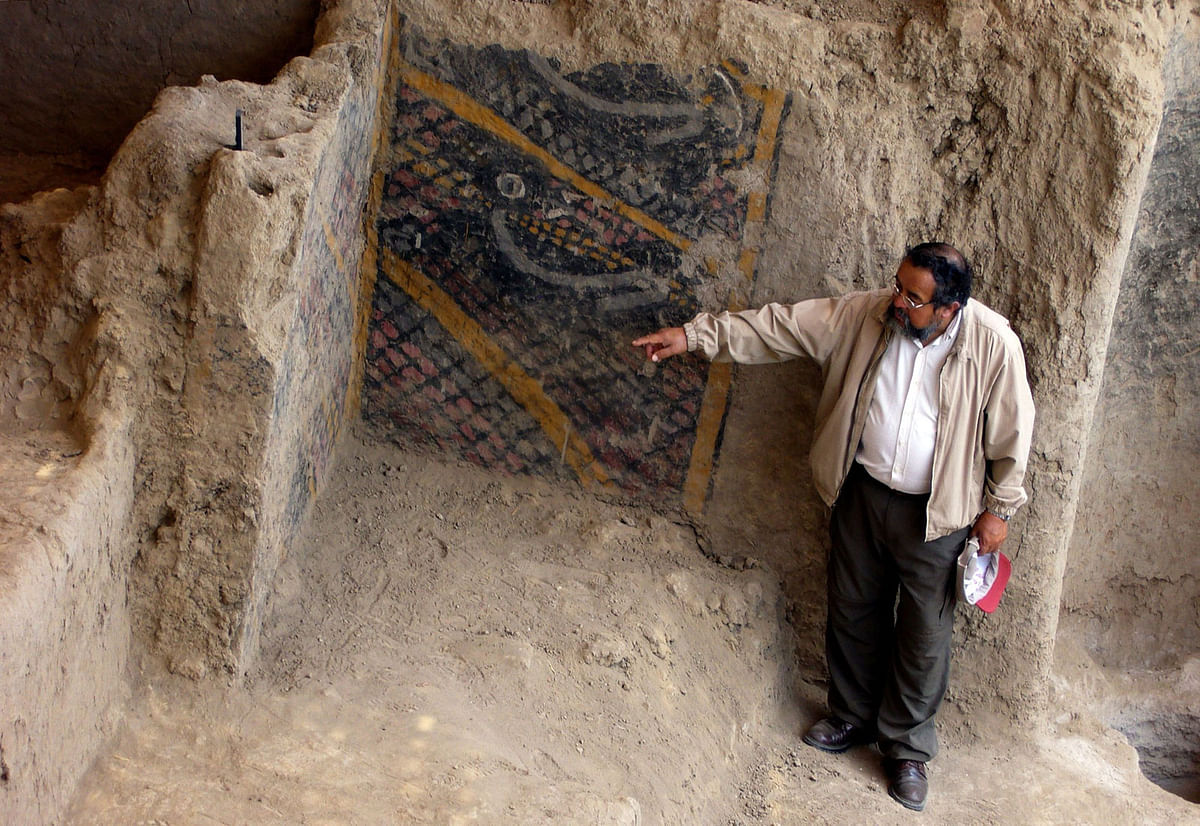 This handout file photo taken and released by Peruvian national news service Andina on 10 November, 2007 shows Peruvian archaeologist Walter Alva pointing what is supposed to be the most ancient mural painting in America, in a temple in Chiclayo, more than 1000 kms north of Lima. Photo: AFP