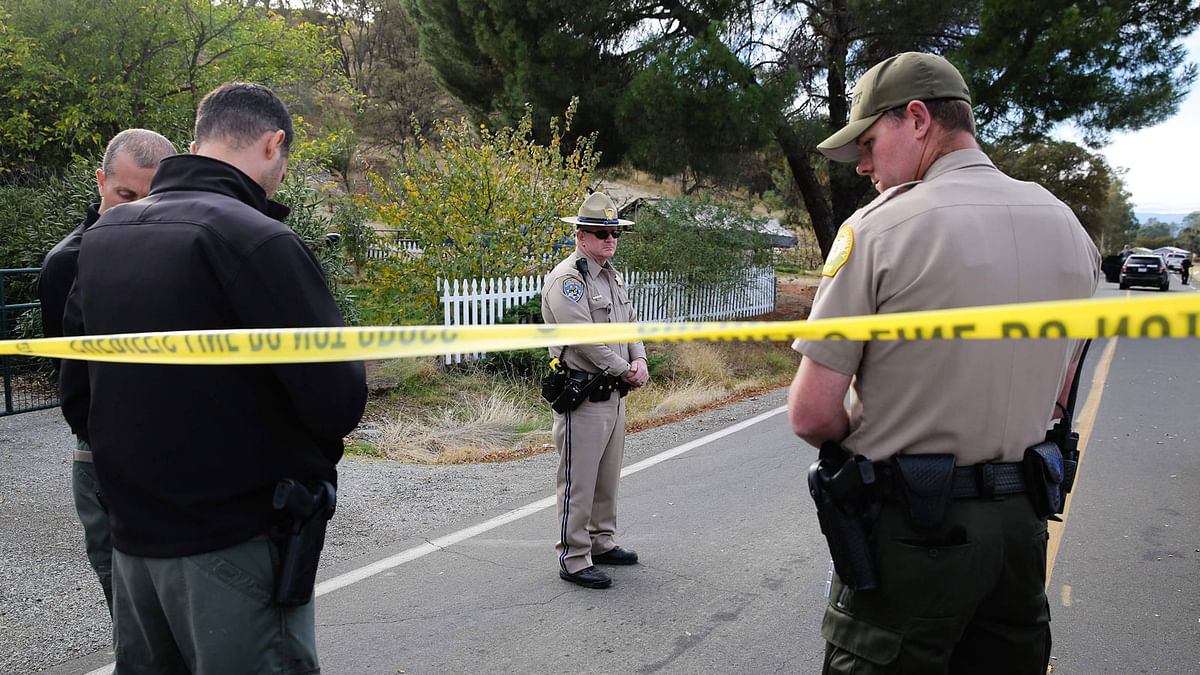 Law enforcement officers stand near one of many crime scenes after a shooting in Rancho Tehama, California, US. Photo: AFP