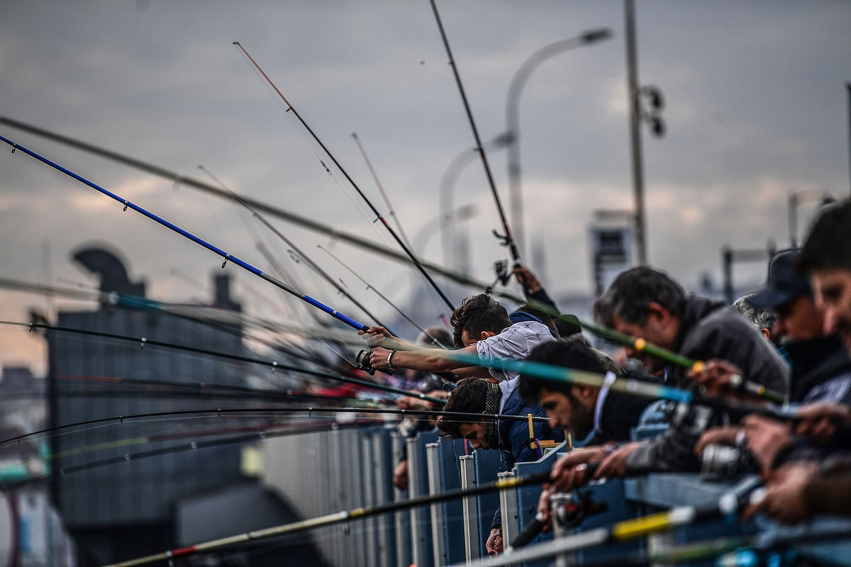 People are fishing on galata bridge at Karakoy district in Istanbul. AFP file photo