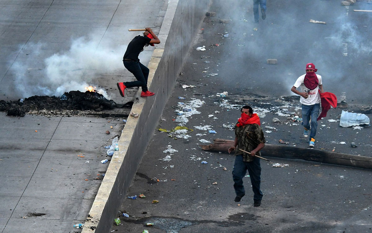 Supporters of Honduran presidential candidate for the Opposition Alliance against the Dictatorship coalition Salvador Nasralla, clash with security forces during protests demanding the final results of the weekend’s presidential election, in Tegucigalpa on Friday. Photo: AFP
