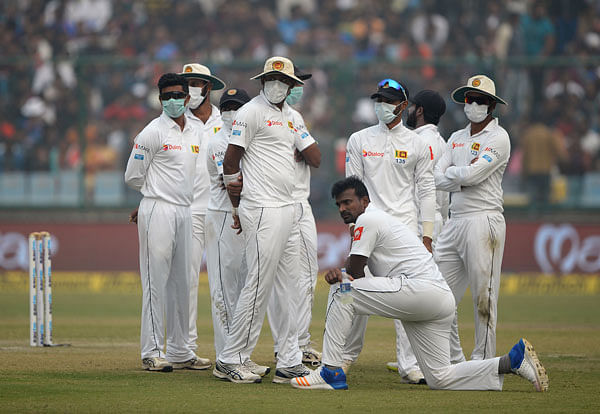 Sri Lanka cricket players wear masks in an attempt to protect themselves from air pollution during the second day of the third Test cricket match between India and Sri Lanka at the Feroz Shah Kotla Cricket Stadium in New Delhi on 3 December 2017. Photo: AFP