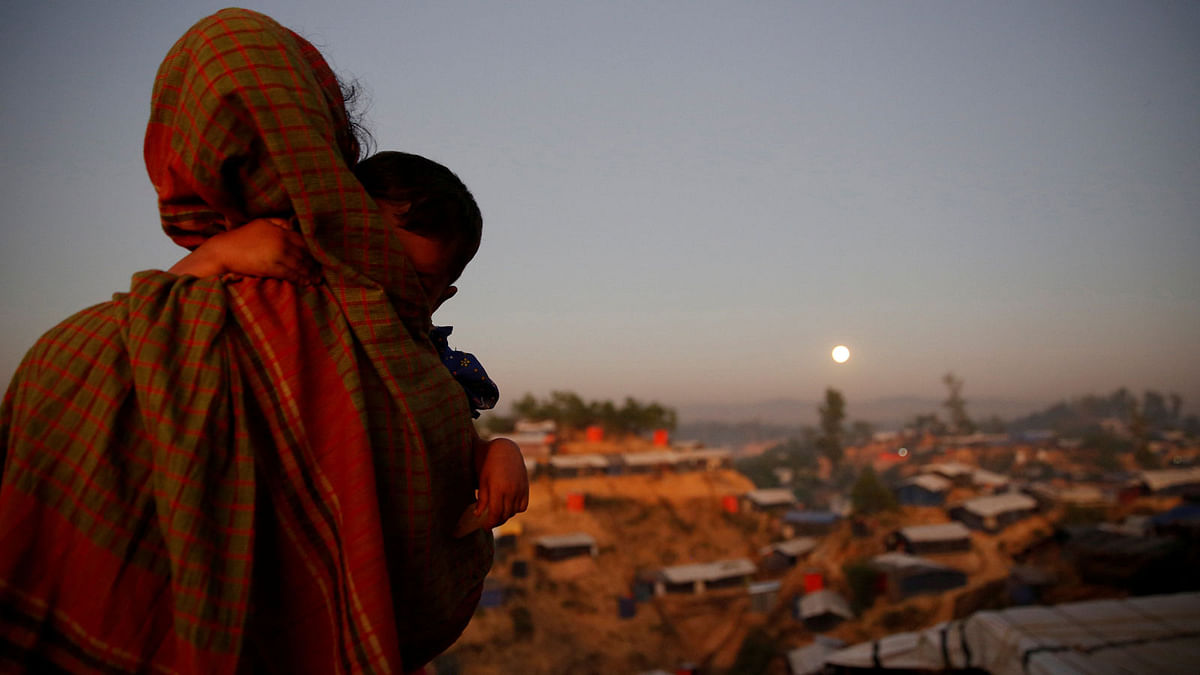 A Rohingya woman looks at the full moon with a child in tow at Balukhali camp near Cox`s Bazar, Bangladesh, 3 December 2017. Photo: Reuters