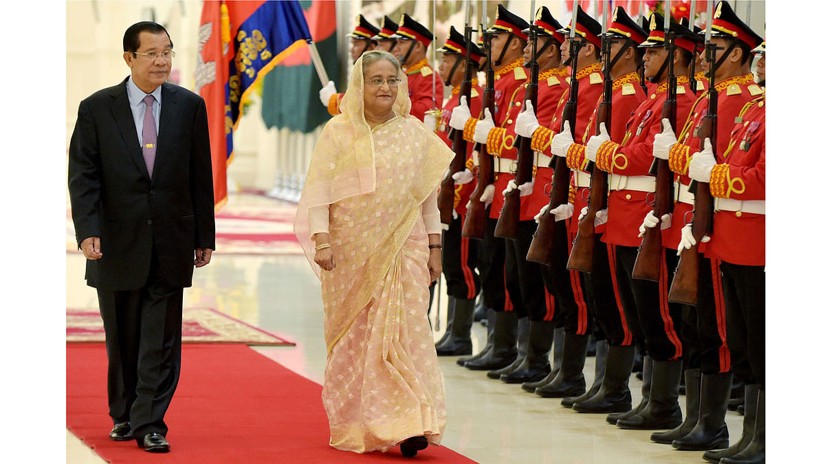 Prime minister Sheikh Hasina (C) and Cambodian prime minister Hun Sen (L) walk past honour guard upon her arrival at the Peace Palace in Phnom Penh on 4 December, 2017. Photo: AFP