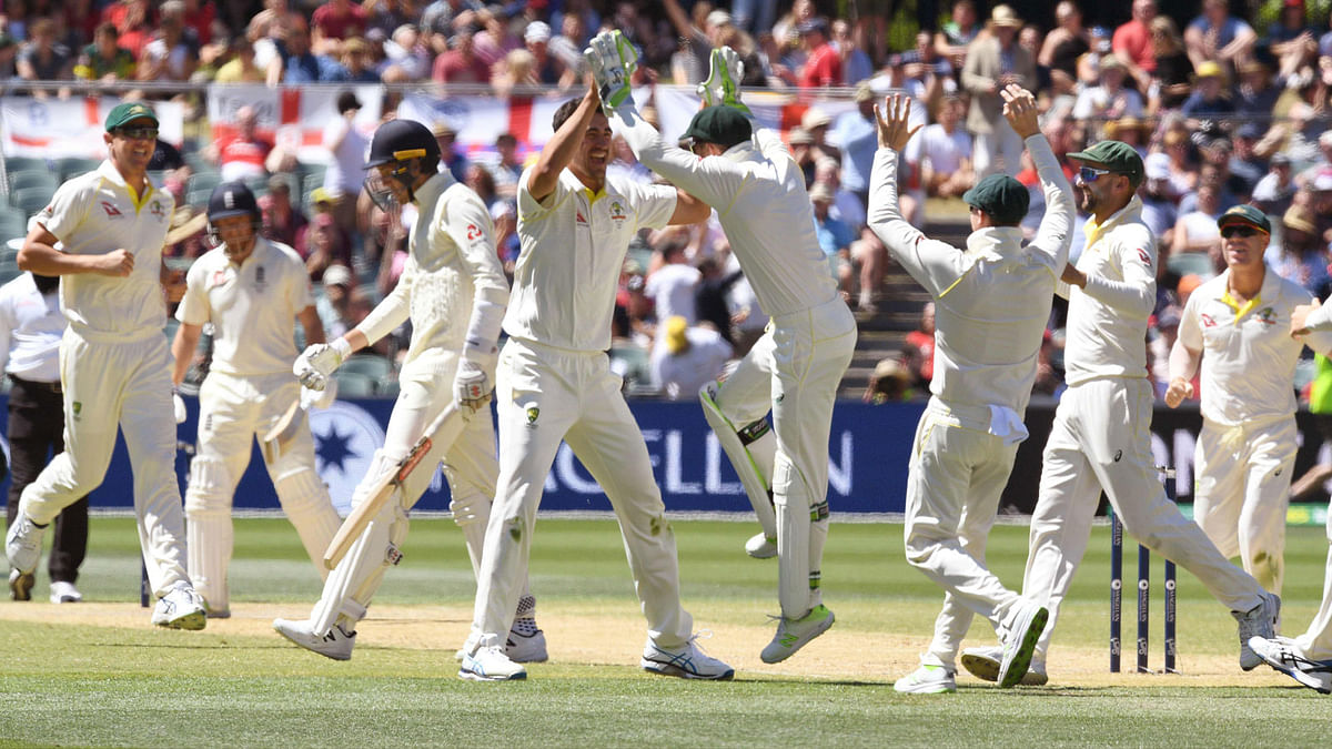 Australia’s Mitchell Starc (4/L) is congratulated by teammates after dismissing England batsman Craig Overton (3/L) on the final day of the second Ashes cricket Test match in Adelaide