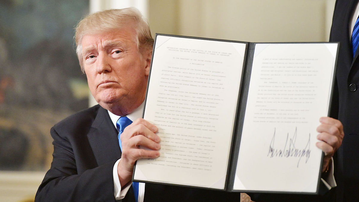 US President Donald Trump holds up a signed memorandum after he delivered a statement on Jerusalem from the Diplomatic Reception Room of the White House in Washington, DC on December 6, 2017. President Donald Trump on Wednesday recognized the disputed city of Jerusalem as Israel's capital -- a historic decision that overturns decades of US policy and risks triggering a fresh spasm of violence in the Middle East.'I have determined that it is time to officially recognize Jerusalem as the capital of Israel,' Trump said from the White House.'It's the right thing to do.' AFP
