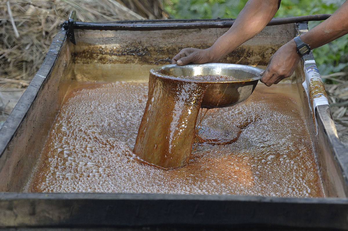 A man boils the sap of the date juice to prepare jaggery `cane sugar` in DodhIabari village near Gajoldoba, around 41 kms from Siliguri on 20 December 2017. The traditional processing of jaggery, which is made from the sap of the date palm, is available only from November to January. Photo: AFP