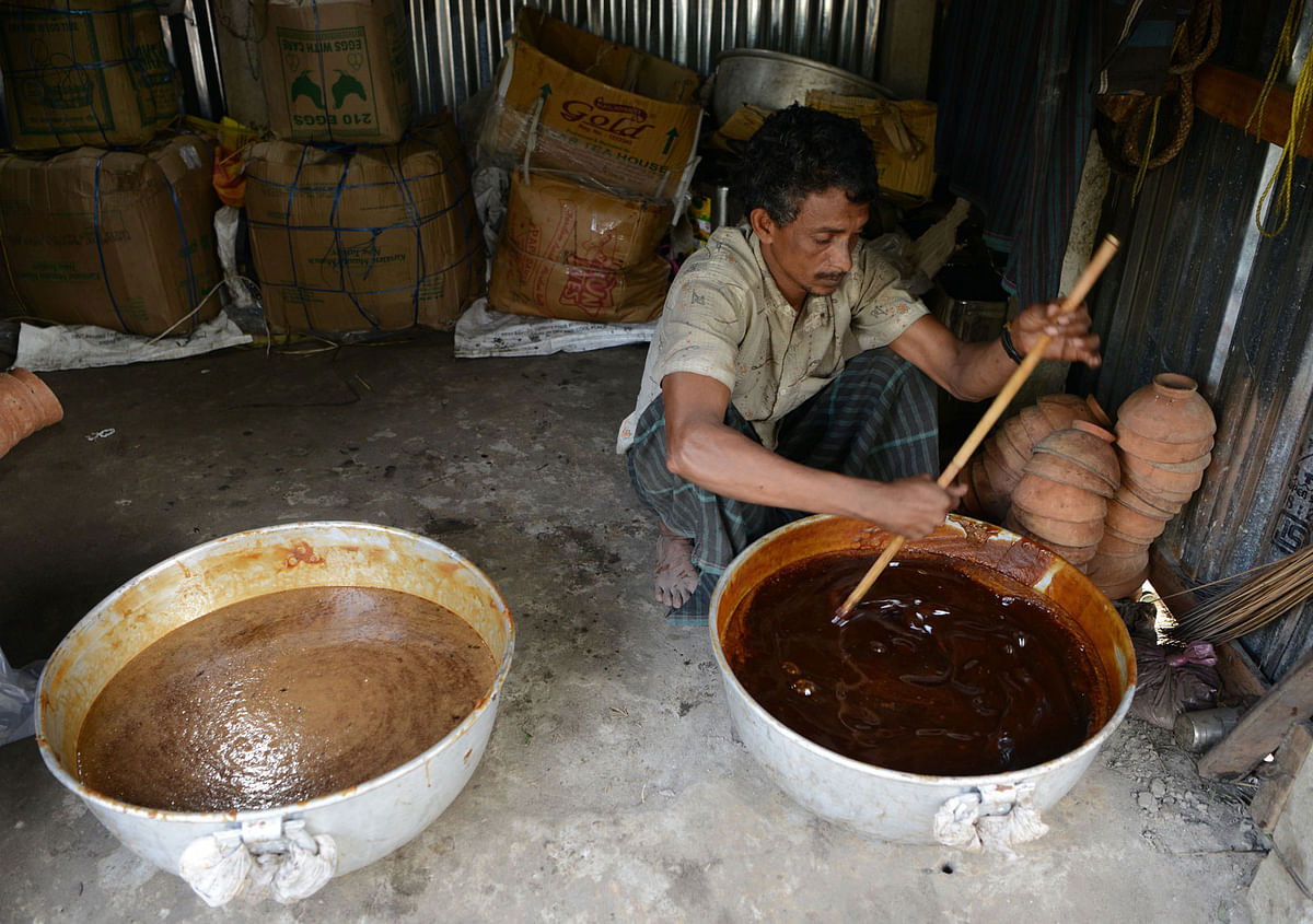 A man boils the sap of the date juice to prepare jaggery `cane sugar` in Dodhiabari village near Gajoldoba, around 41 km from India’s Siliguri on 20 December 2017. Photo: AFP
