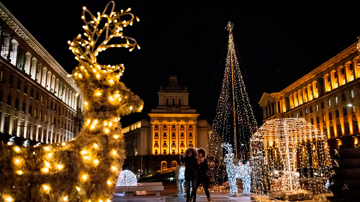 Women take a selfie next to Christmas decoration and lights in Bulgaria on 20 December. Photo: AFP