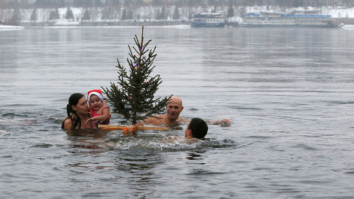 Members of the Cryophile amateurs winter swimmers club swim with a Christmas tree in icy waters of the Yenisei river in Krasnoyarsk, Russia on 23 December. Photo: Reuters