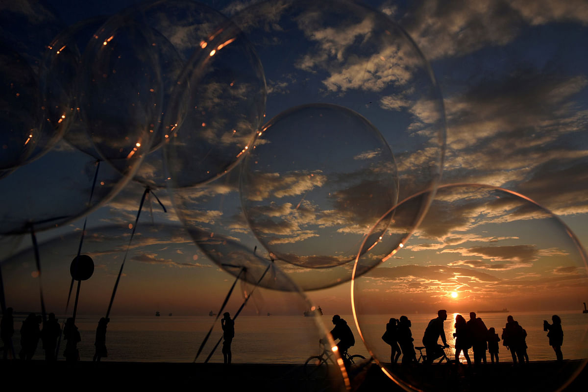 People are seen through balloons as they make their way at the seaside promenade of the northern port city of Thessaloniki. Photo: Reuters