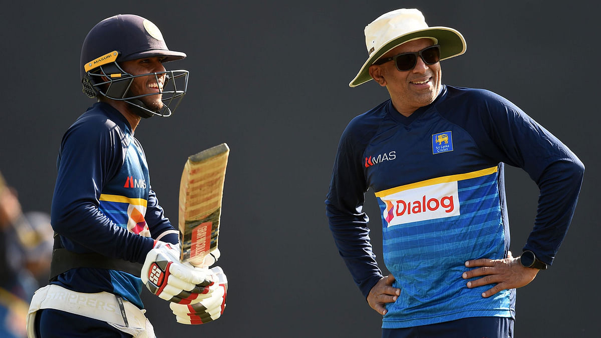 Sri Lanka`s newly-appointed head cricket coach Chandika Hathurusingha (R) speaks with Kusal Mendis during a practice session at the R. Premadasa Stadium in Colombo on December 28, 2017. Sri Lanka are scheduled to take part in a tri-nation, one-day international series in January against Zimbabwe and Bangladesh in Dhaka. AFP