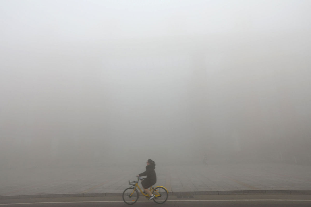 A cyclist is seen amid heavy fog in Jinan, Shandong province, China on 29 December 2017. Photo: Reuters