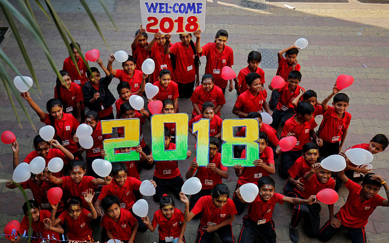 Schoolchildren hold balloons as they pose during celebrations to welcome the New Year at their school in Ahmedabad, India, on 30 December 2017. Photo: Reuters