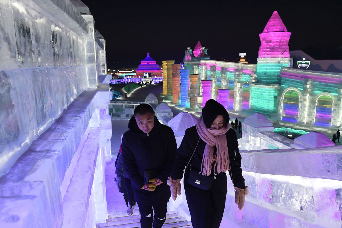 People climb up an ice sculpture at the Harbin Ice and Snow World, part of the annual Harbin Ice and Snow Sculpture Festival in Harbin in China`s northeast Heilongjiang province on 4 January 2018. Photo: AFP