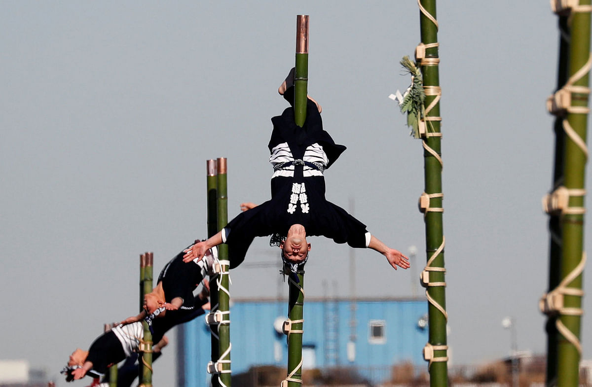 Members of the Edo Firemanship Preservation Association display their balancing skills atop bamboo ladders during New Year`s Fire review in Tokyo, Japan on 6 January. Photo: Reuters