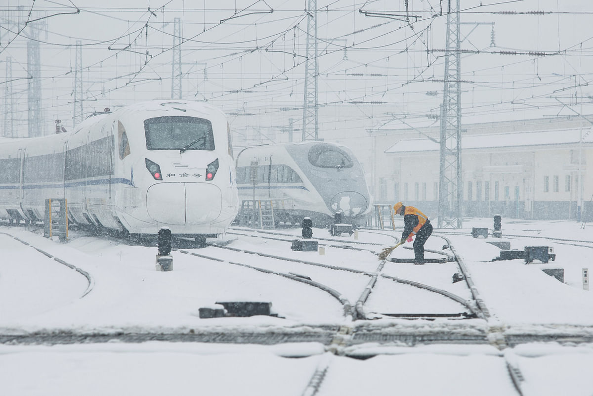 A worker removes snow from railways of high-speed train service in Xi`an, Shaanxi province, China on 6 January, 2018. Photo: Reuters