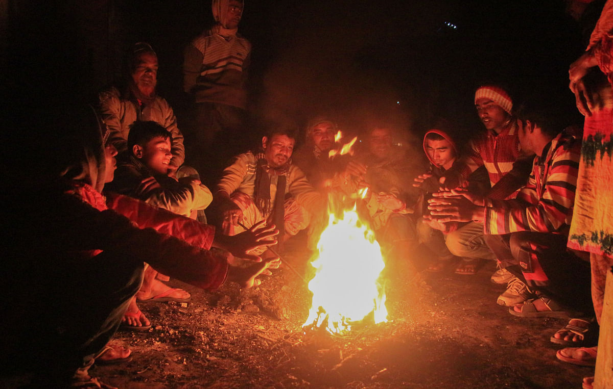 A group of men warms up in front of a fire at Bastuhara area of Khulna on 6 January as cold grips the country. Photo: Saddam Hossain