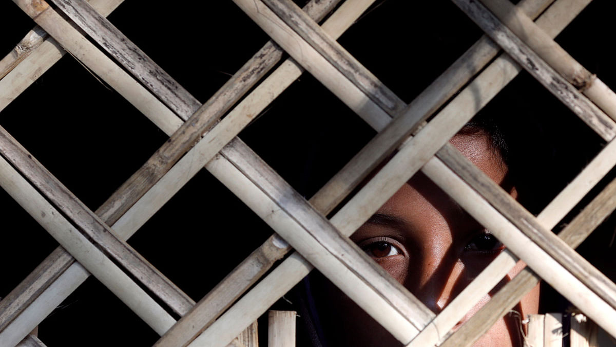A Rohingya child looks from inside a shelter home at Kutupalong Refugee Camp in Cox`s Bazar on 8 January. Photo: Reuters