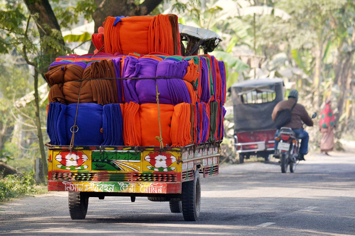 A pick-up van is carrying winter clothes from Pabna town to Ishwardi upazila on 9 January 2018. Photo: Hasan Mahmud