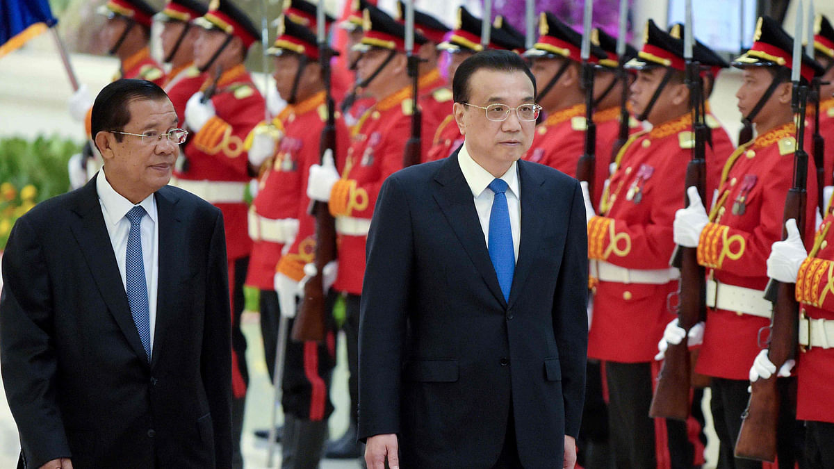 Cambodian prime minister Hun Sen (L) and Chinese Premier Li Keqiang (C) walk past the honour guard at the Peace Palace in Phnom Penh on 11 January, 2018. Photo: AFP