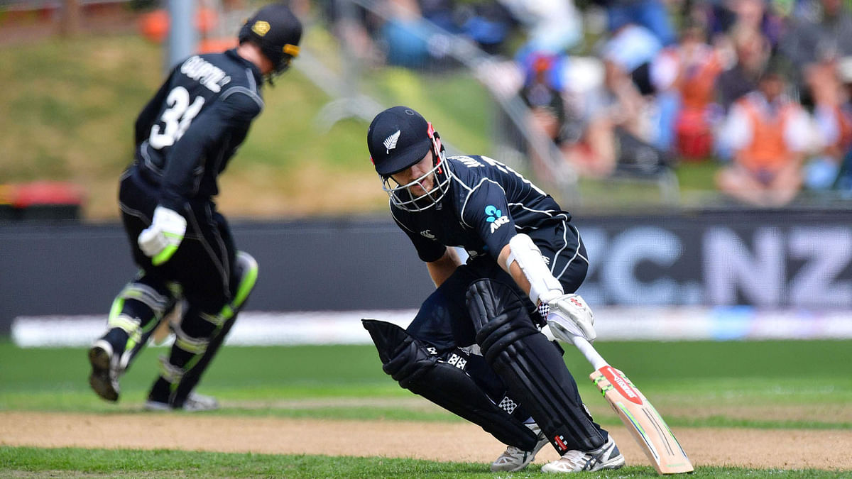 New Zealand's captain Kane Williamson (R) makes a run with team mate Martin Guptill during the third one day international cricket match between New Zealand and Pakistan at University Oval in Dunedin on 13 January 2018. AFP