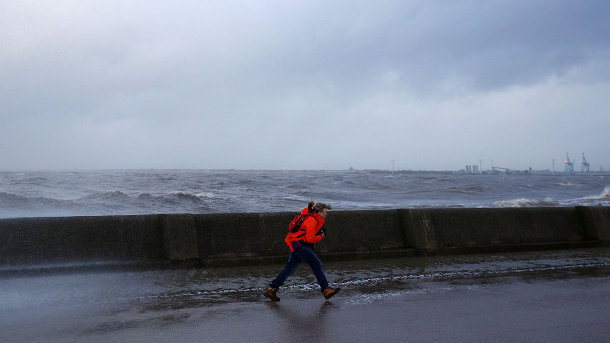 A walker battles against the wind as they walk by the sea in New Brighton, on the coast of the Wirral peninsula, in Merseyside, Britain, 3 January, 2018. Photo: Reuters