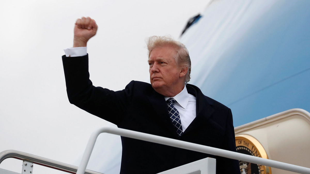 US president Donald Trump pumps his fist as he boards Air Force One upon departure from Joint Base Andrews in Maryland, US, on 12 January 2018. Reuters