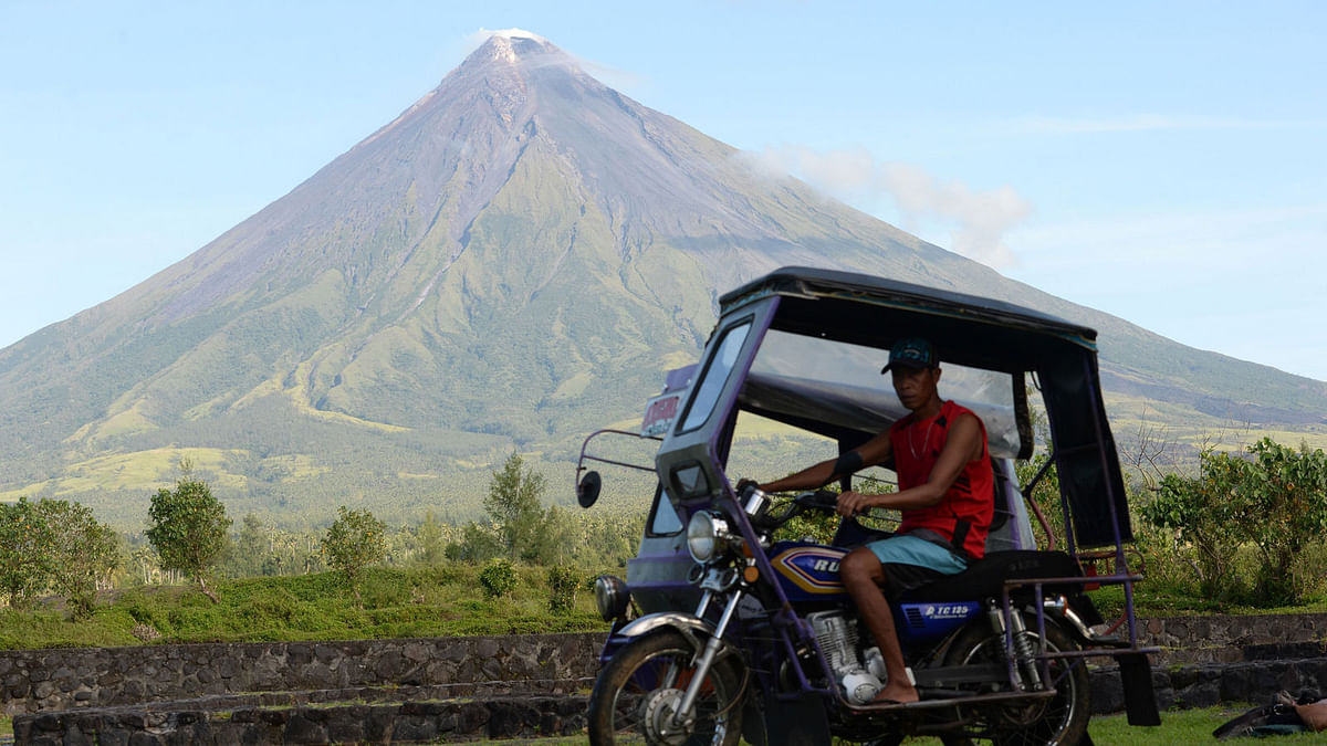 A motorised tricycle speeding past the Mayon volcano near the city of Legazpi, Albay province. AFP file photo