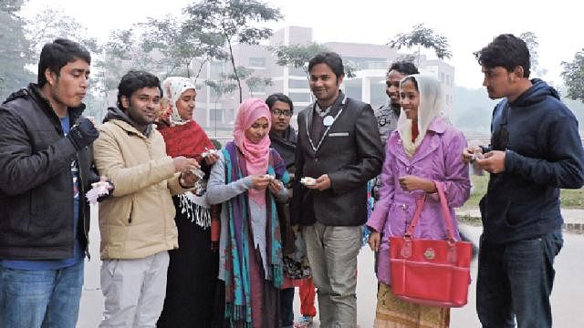 Students of Hajee Mohammad Danesh Science and Technology University (HSTU) take pitha in a winter afternoon. Photo: Prothom Alo