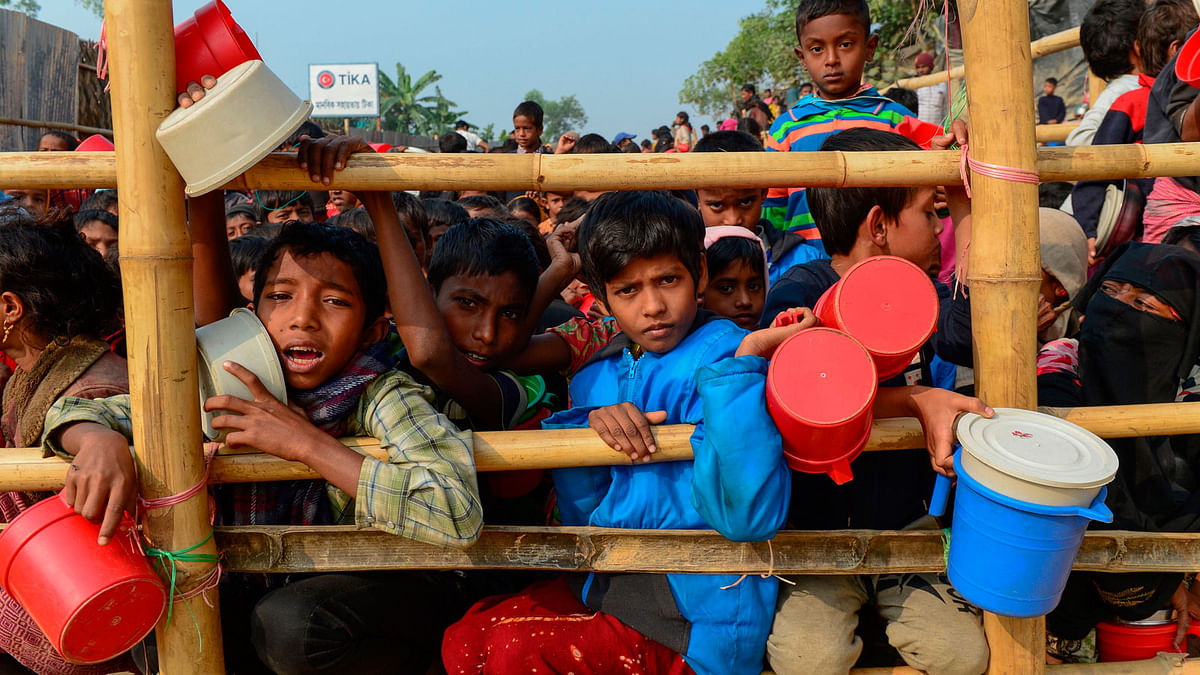 Rohingya Muslim refugees wait for food aid at Thankhali refugee camp in Ukhia of Bangladesh on 12 January 2018. AFP