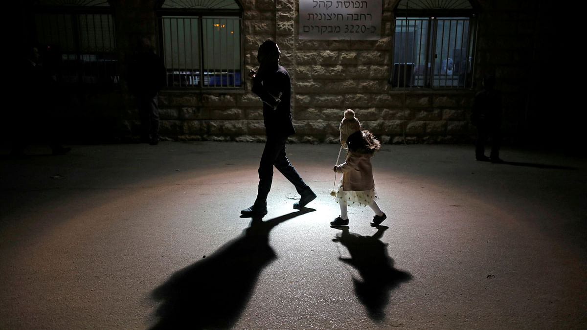 A Jewish worshipper and his daughter are seen during an annual pilgrimage to the gravesite of Rabbi Yisrael Abuhatzeira, a Moroccan-born sage and Kabbalist also known as the Baba Sali, on the anniversary of his death in the southern town of Netivot, Israel, 18 January 2018. Photo: Reuters