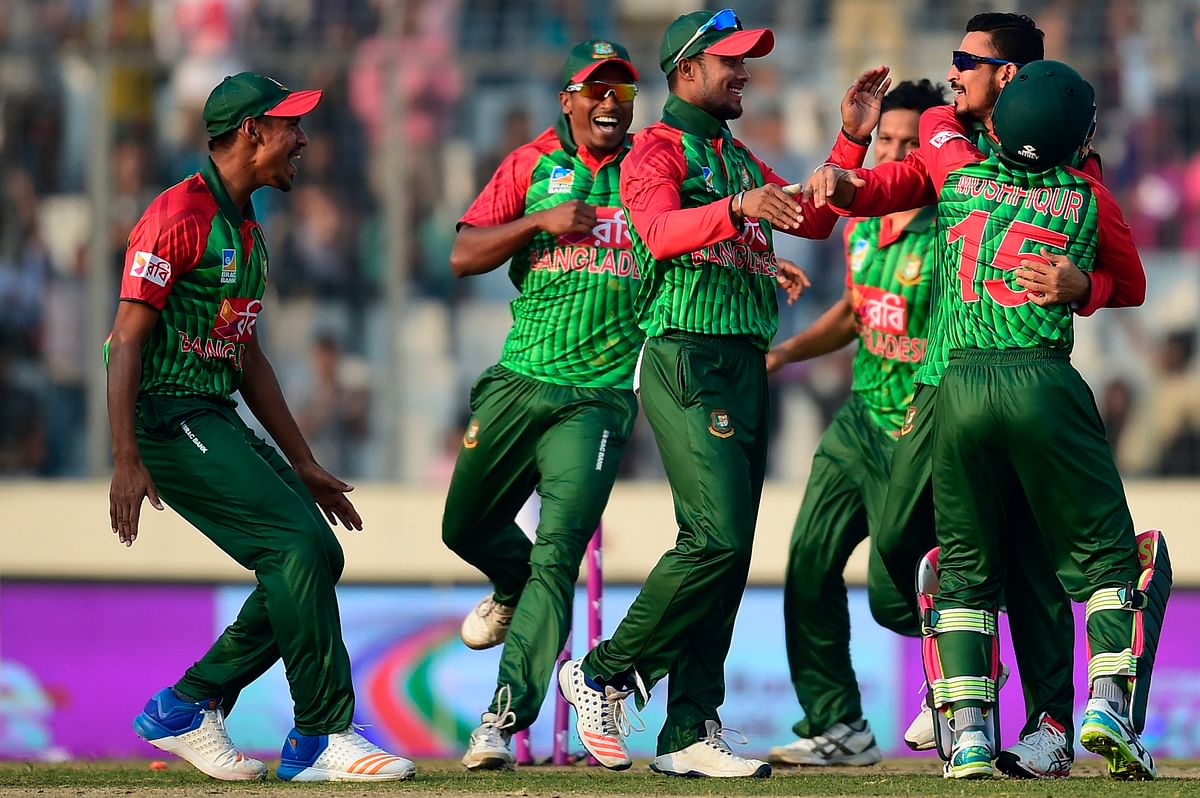 Bangladesh cricketer Nasir Hossain (2nd L) celebrates with his teammates after the dismissal of the Sri Lanka cricketer Kusal Perera reacts during the third one day international (ODI) cricket match of the Tri-Nations Series between Bangladesh and Sri Lanka at the Sher-e-Bangla National Cricket Stadium in Dhaka on 19 January 2018. AFP