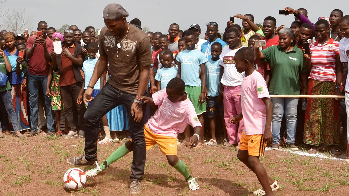 Ivory Coast`s football star Didier Drogba plays football with pupils on the football ground of the Primary School Didier Drogba during its inauguration on 18 January 2018 in Pokou-Kouamekro, near Gagnoa, central-western Ivory Coast. AFP