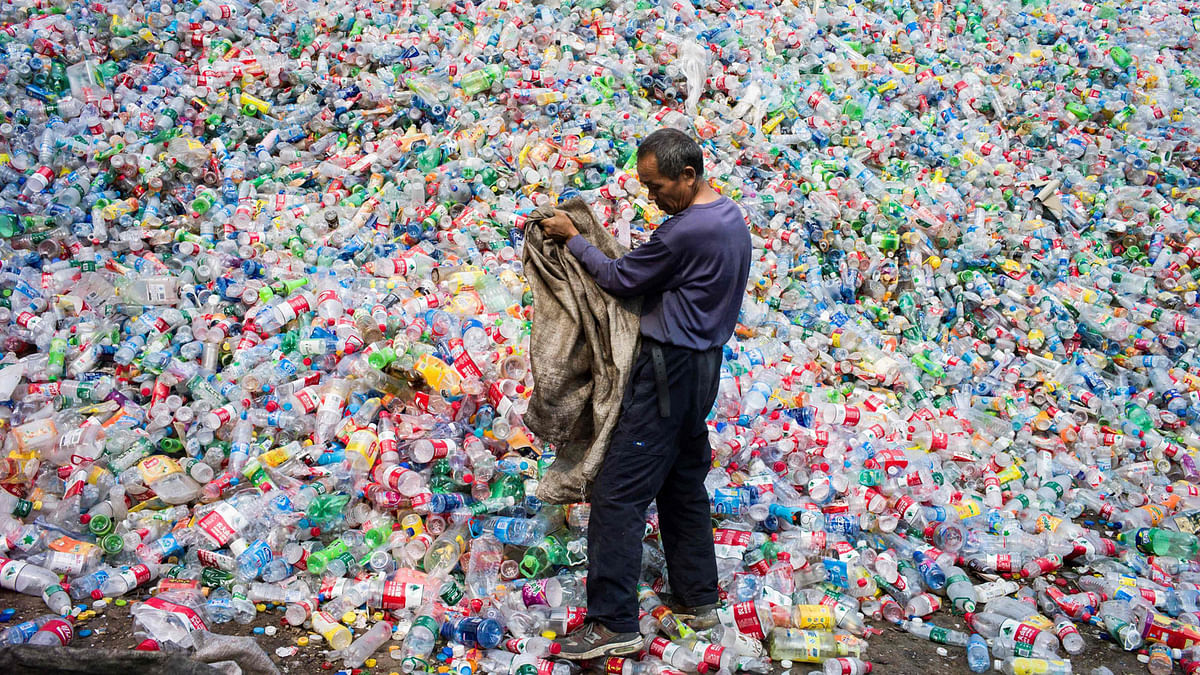 This file photo taken on 17 September 2015 shows a Chinese labourer sorting out plastic bottles for recycling in Dong Xiao Kou village, on the outskirt of Beijing. AFP