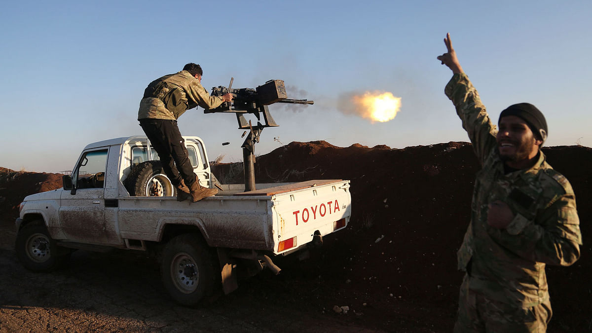 Turkish-backed fighters from the Free Syrian Army stand in the Tal Malid area, north of Aleppo, as they fire towards Kurdish People’s Protection Units (YPG) positions in the village of Um al-Hosh, in the area of Afrin, on Saturday. Photo: AFP
