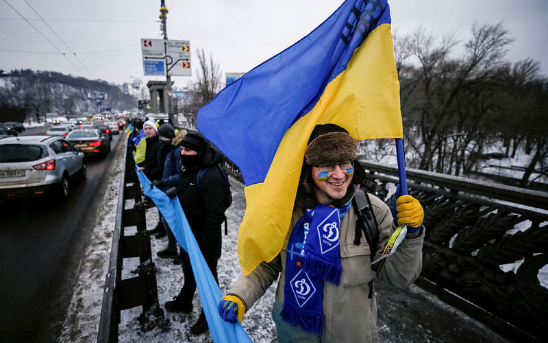 People carry national flags on a bridge while forming a human chain across the Dnipro River during celebrations for Unity Day in Kiev, Ukraine on 22 January. Photo: Reuters