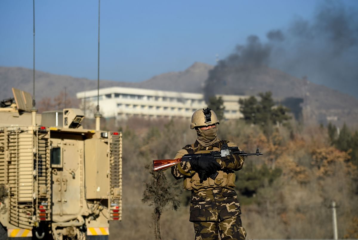 An Afghan security personnel stands guard as smoke billows from the Intercontinental Hotel during a fight between gunmen and Afghan security forces in Kabul on Sunday. Photo: AFP