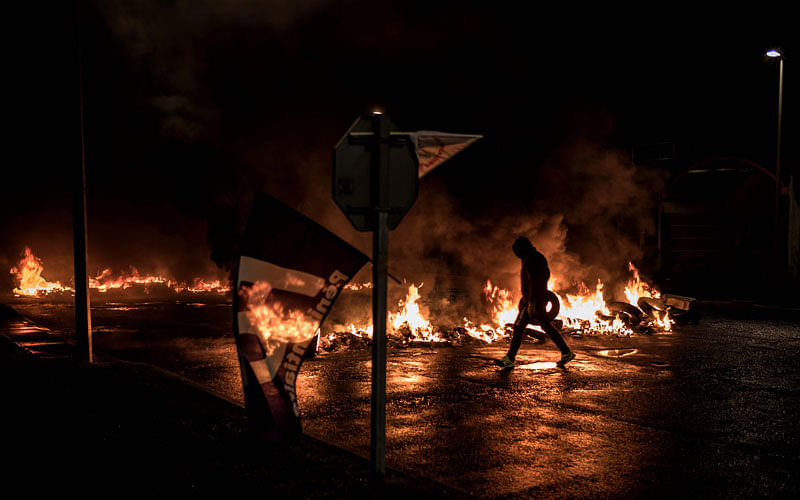 Striking prison guards lit a fire in front of Villefranche-sur-Saone prison on 22 January as part of a nationwide movement to call for better safety and wages. Photo: AFP