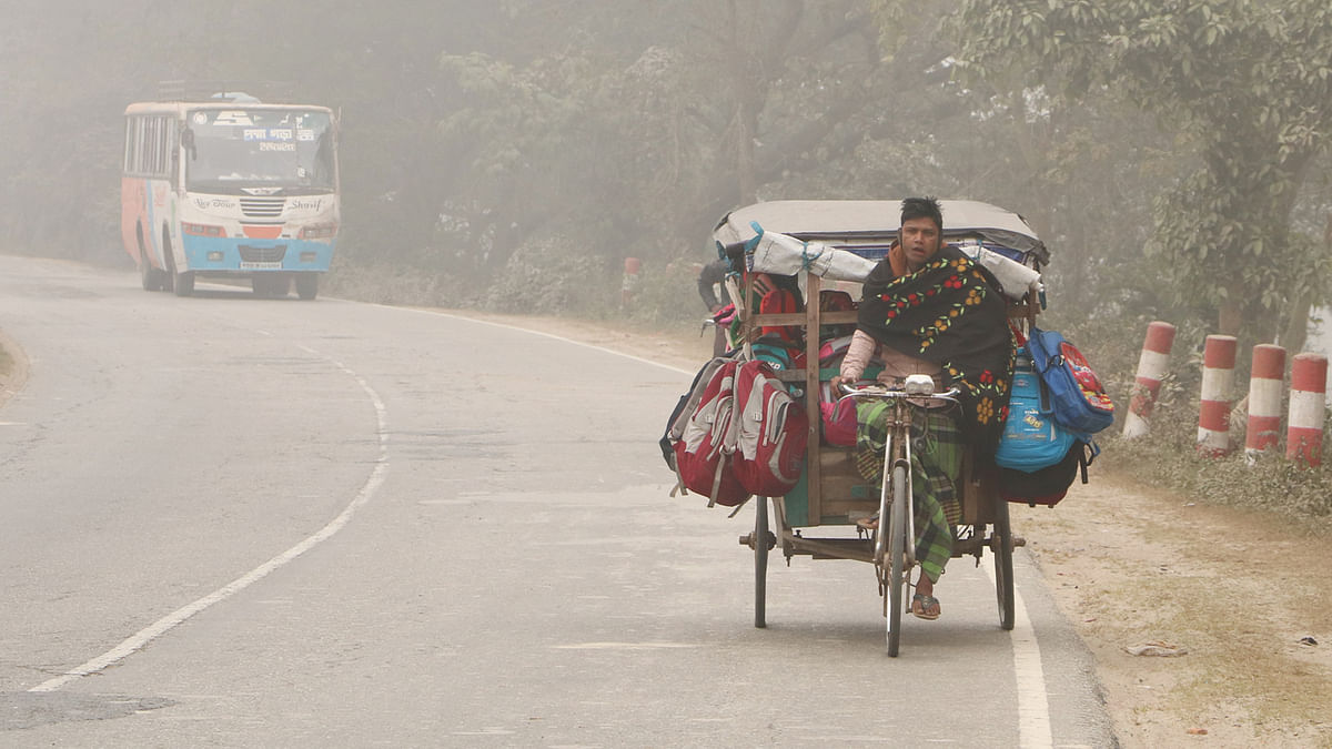 A van carrying kids to school at on a foggy morning along Khulna-Daulatdia highway in Gualunda Bazar of Rajbari on 23 January 2018. Photo: M Rashedul Haque