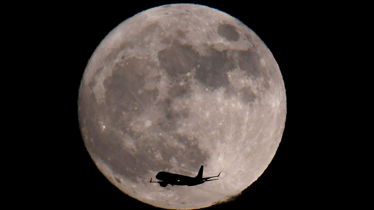 A passenger plane, with a `supermoon` full moon seen behind, makes its final landing approach towards Heathrow Airport in London. Reuters
