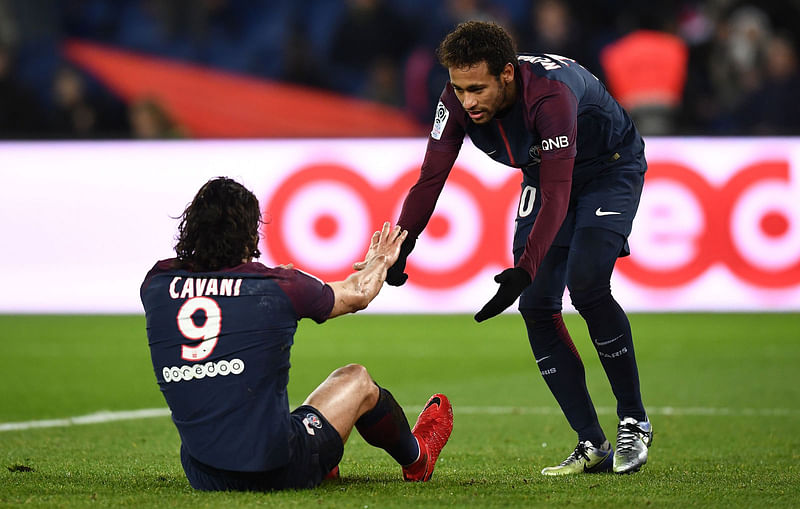 Paris Saint-Germain’s Brazilian forward Neymar ® helps up Paris Saint-Germain’s Uruguayan forward Edinson Cavani during the French L1 football match between Paris Saint-Germain (PSG) and Montpellier (MHSC) at the Parc des Princes stadium in Paris on Saturday. Photo: AFP